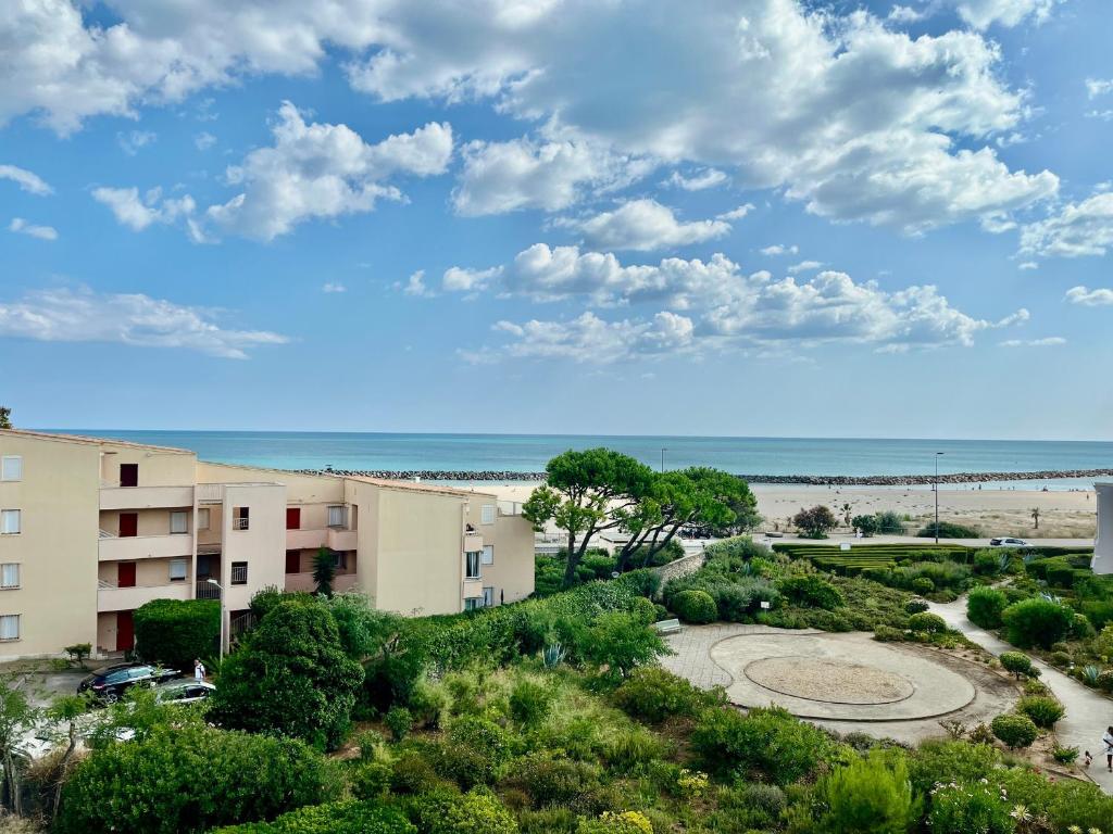 - une vue sur un bâtiment et la plage dans l'établissement Appartement pour 4 face à la mer avec parking privé, à Sète - FR-1-338-619, à Sète