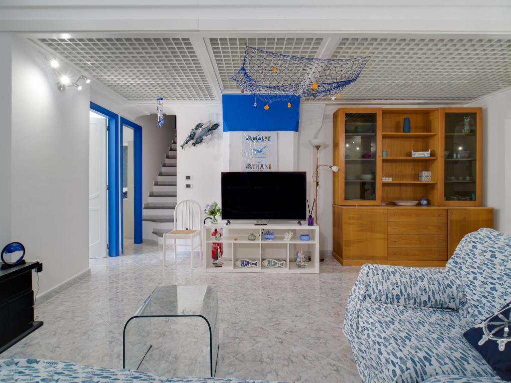 a living room with a couch and a tv at Blue Atrani Central House - 150 mt dalla spiaggia in Atrani