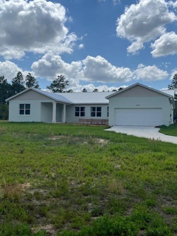 a large white house with a garage at Modern & Peaceful Retreat Near WEC & Ocala Amenities in Ocala