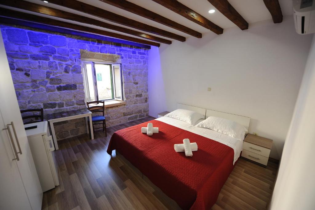 a bedroom with a red bed with two crosses on it at Top Center in Split