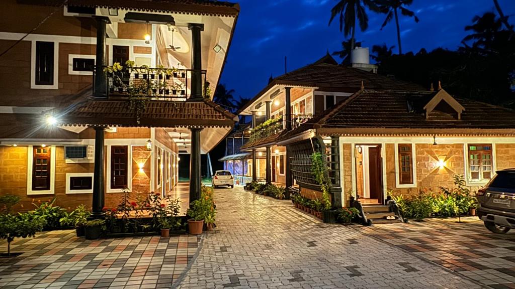 a cobblestone street in front of houses at night at Credible Heritage Resort in Varkala