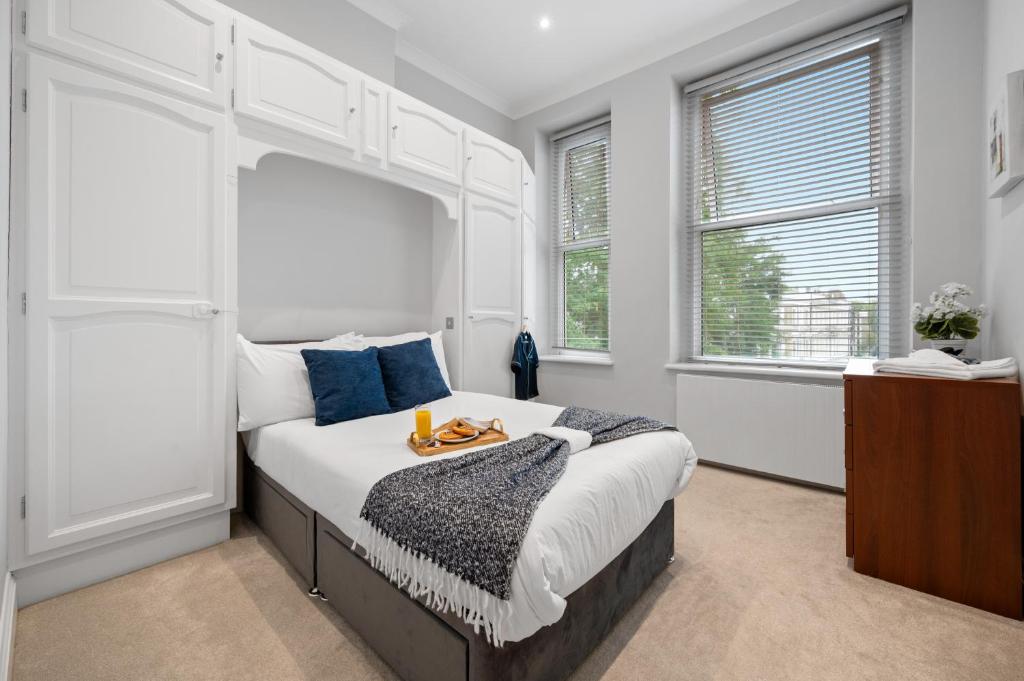 a bedroom with a bed with a tray on it at The Kensington Residence - Central London Base in London