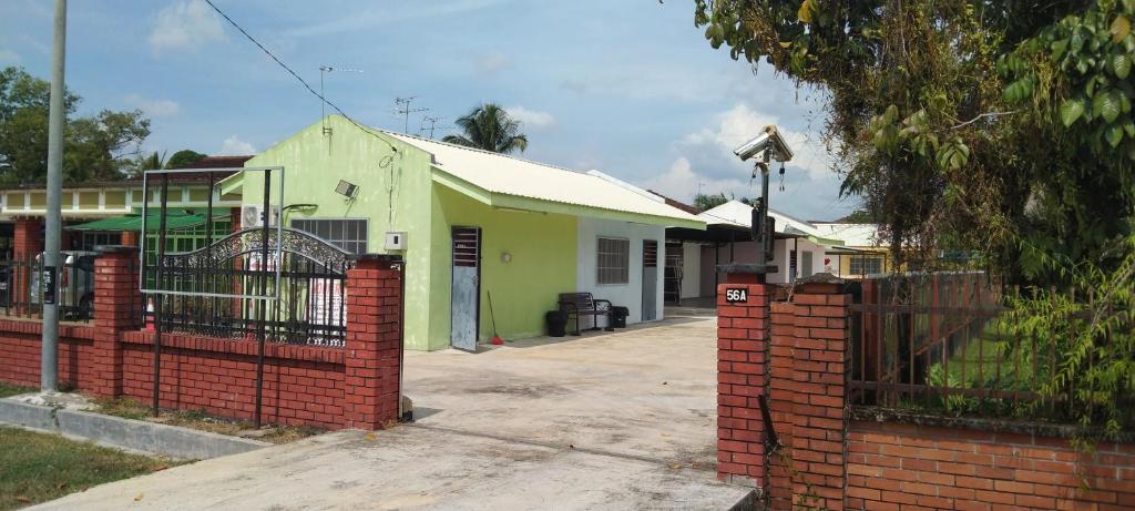 a house with a gate and a brick fence at Noor Roomstay in Taiping