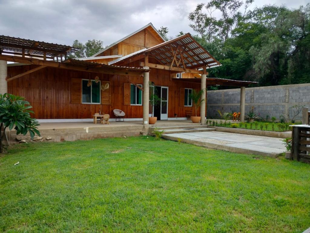 a wooden house with a lawn in front of it at Hermosa Cabaña Familiar en Oaxaca in Oaxaca City