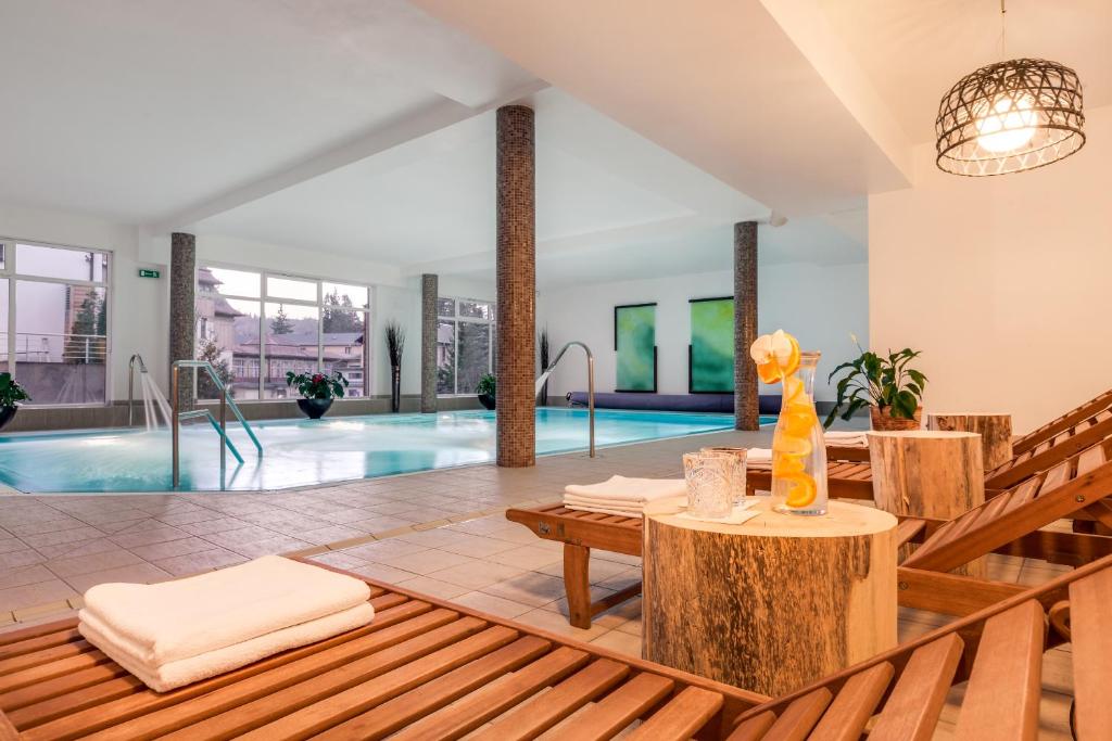 a villa with a swimming pool with a table and chairs at Boutique Eco Hotel Sasanka in Szklarska Poręba