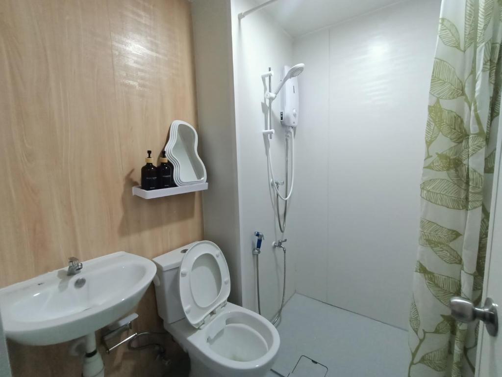 a bathroom with a shower and a toilet and a sink at Staycation Houz,Sepanggar in Kota Kinabalu