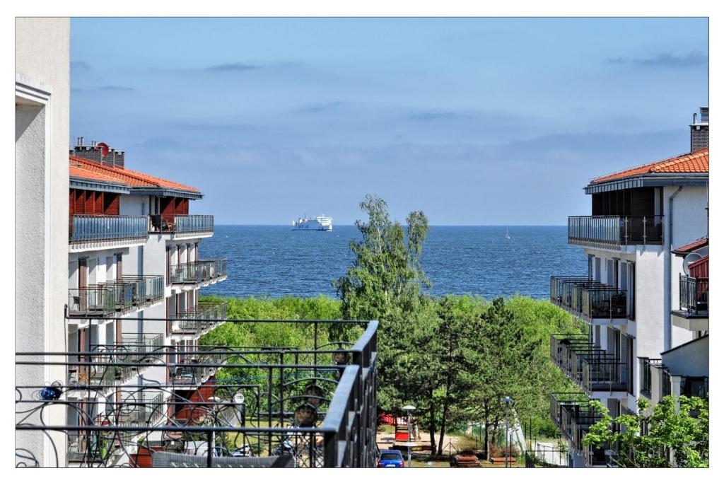 a view of the ocean from between two buildings at Korona Wazów 55 in Świnoujście