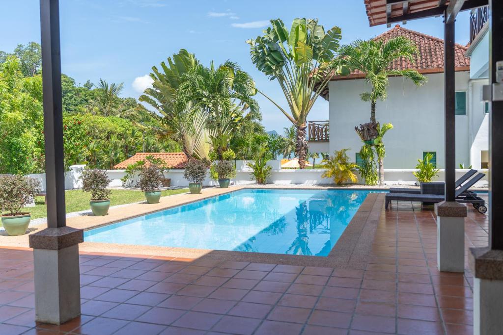 a swimming pool in a villa with palm trees at Villa 6 - Private Pool WOW Holiday Homes in Pantai Cenang