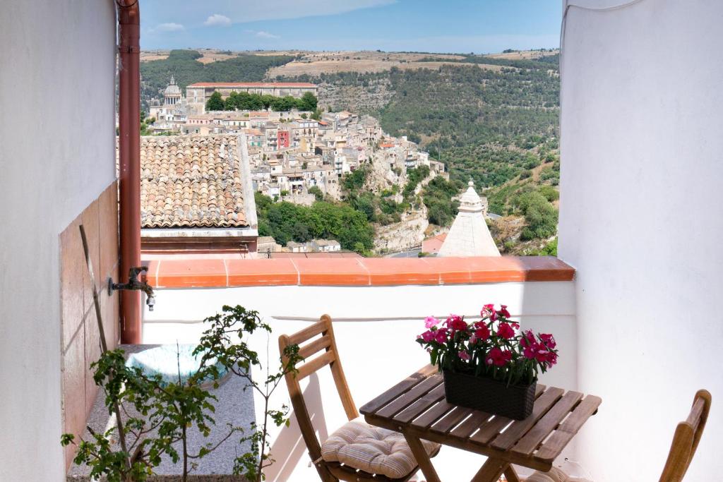 a balcony with a table and chairs and a view of a city at Le Scale Sul Barocco in Ragusa