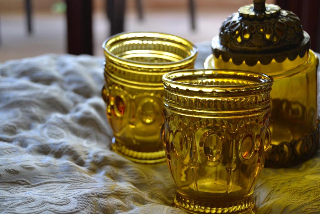 três copos de ouro em cima de uma mesa em Villa Ethnic Chic em Bisceglie