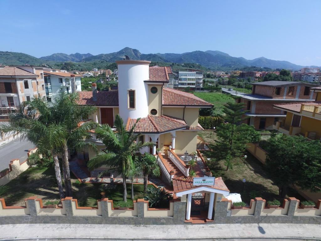 un bâtiment avec une tour d'horloge dans une ville dans l'établissement Villa Manno, à Barcellona-Pozzo di Gotto