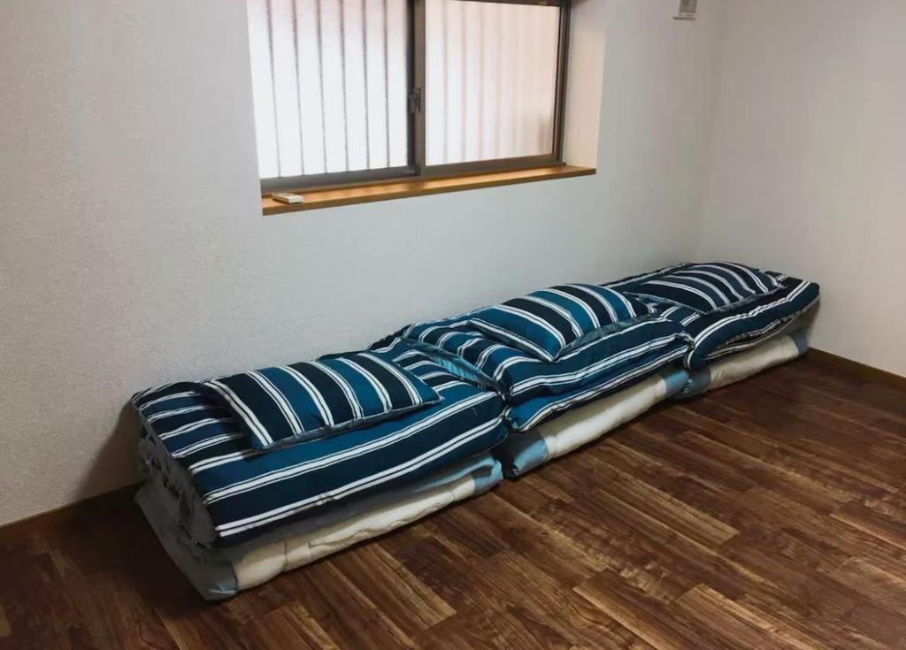 a bed sitting on the floor in a room at 花迹民宿二号馆201 通天阁天王寺步行圈 心斋桥日本桥4分钟车程 in Osaka