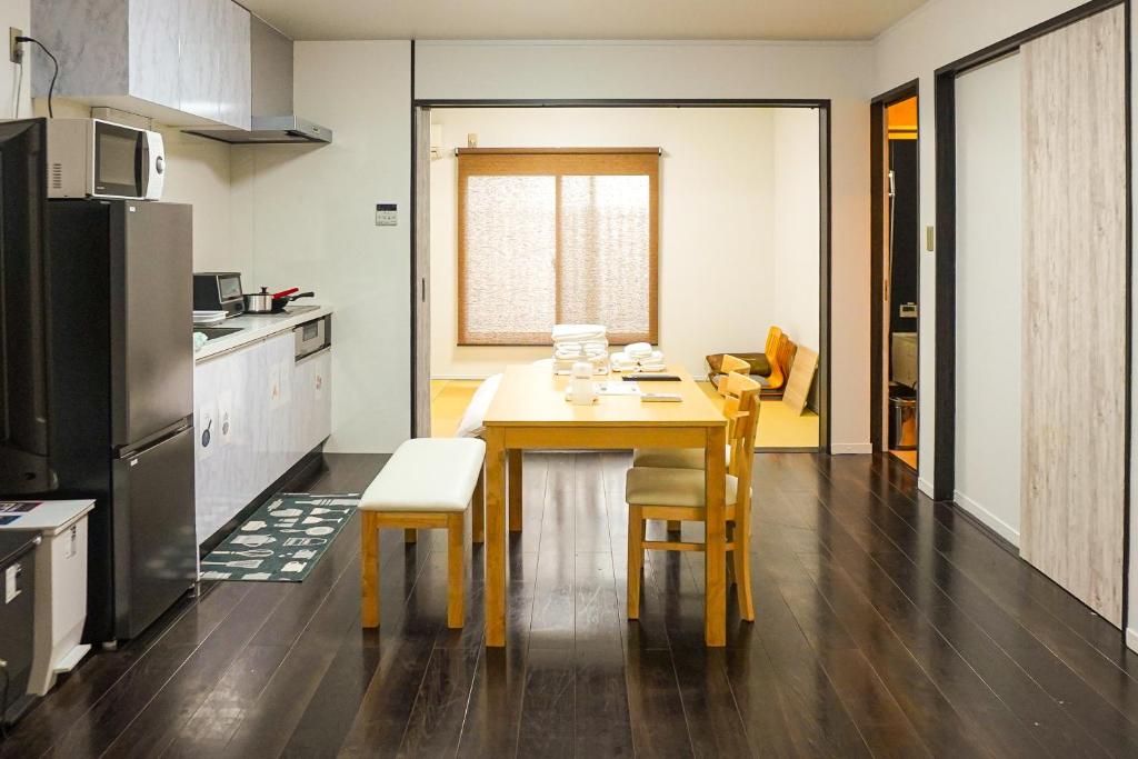 a kitchen with a table and chairs in a room at Imagine Annex in Kyoto
