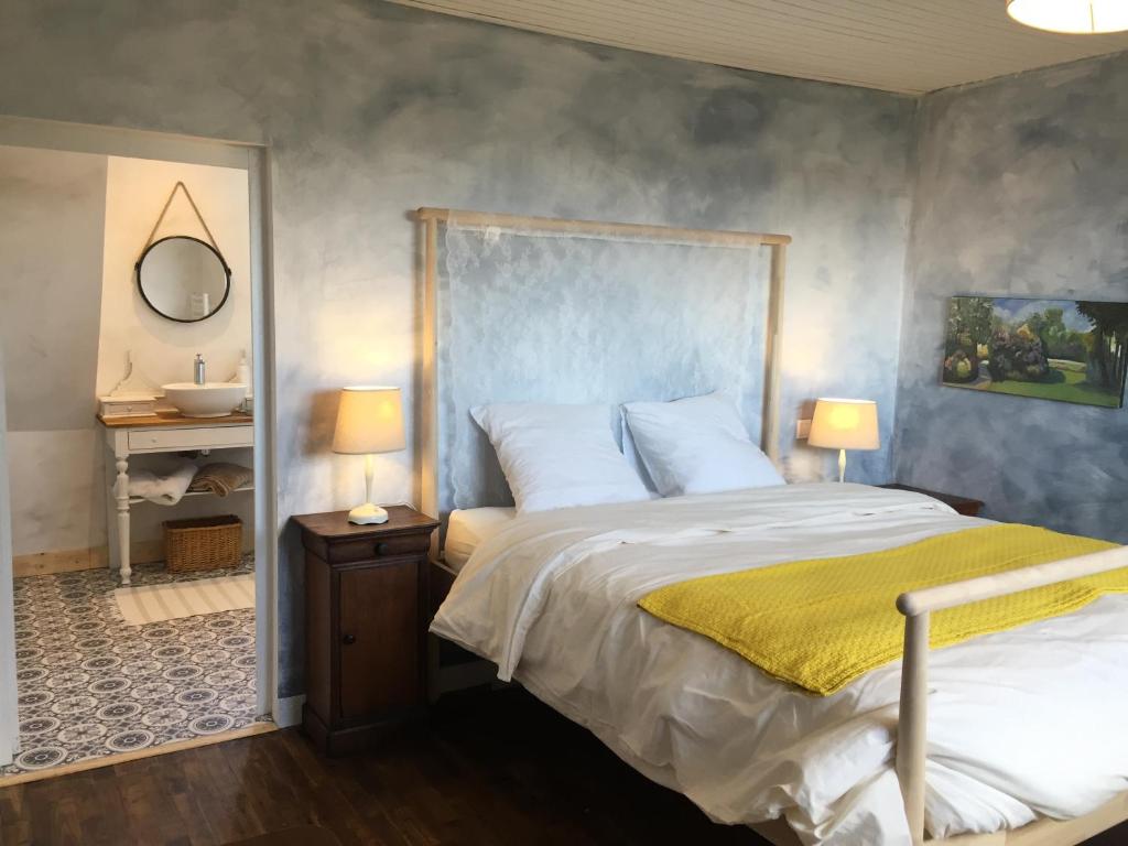 a bedroom with a large bed and a sink at L'Ermitage in Saint-Vaast-la-Hougue