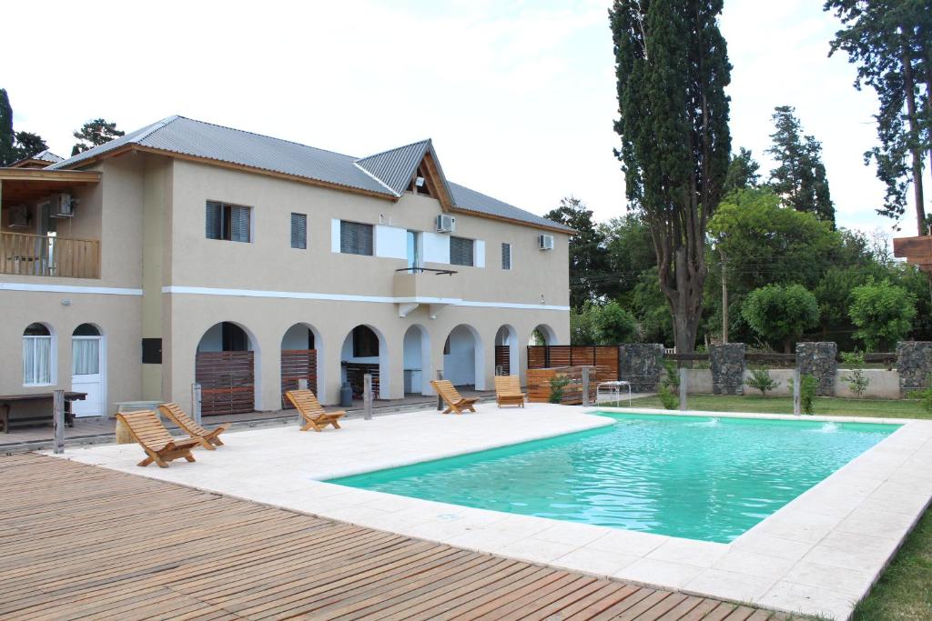 a house with a swimming pool in front of a house at Lago Hotel in Villa Rumipal