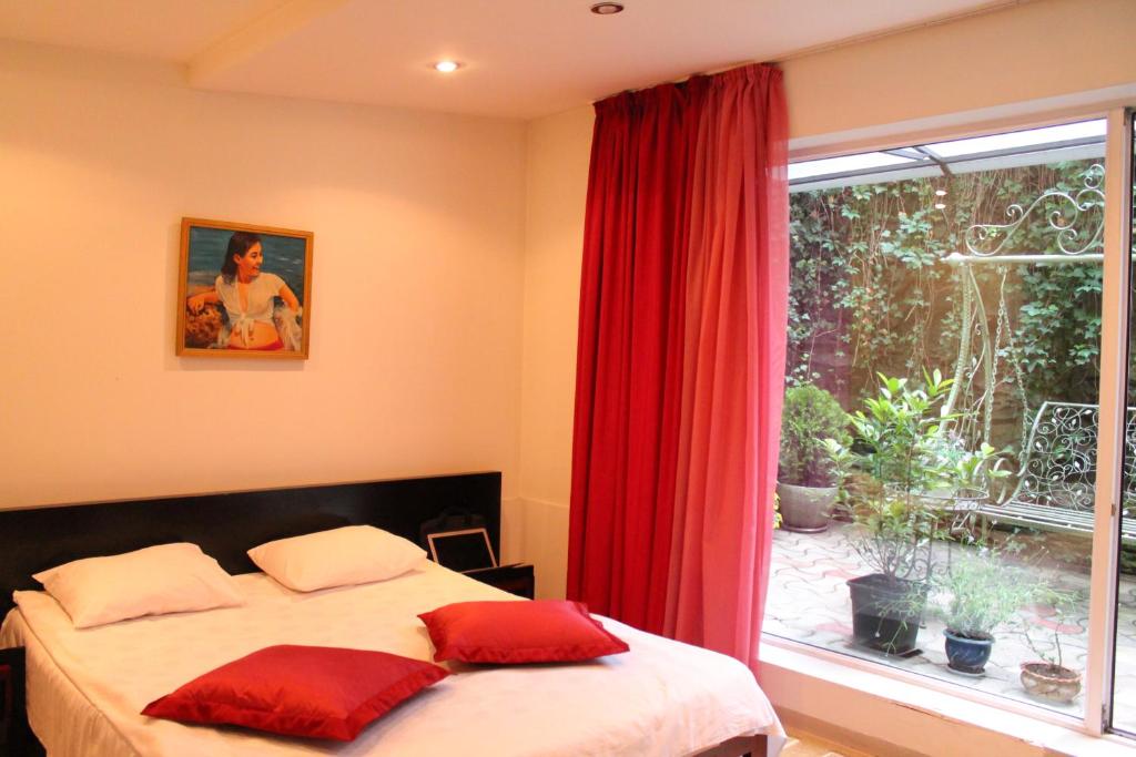 a bedroom with a bed with red curtains and a window at Vake Boutique Hotel in Tbilisi City