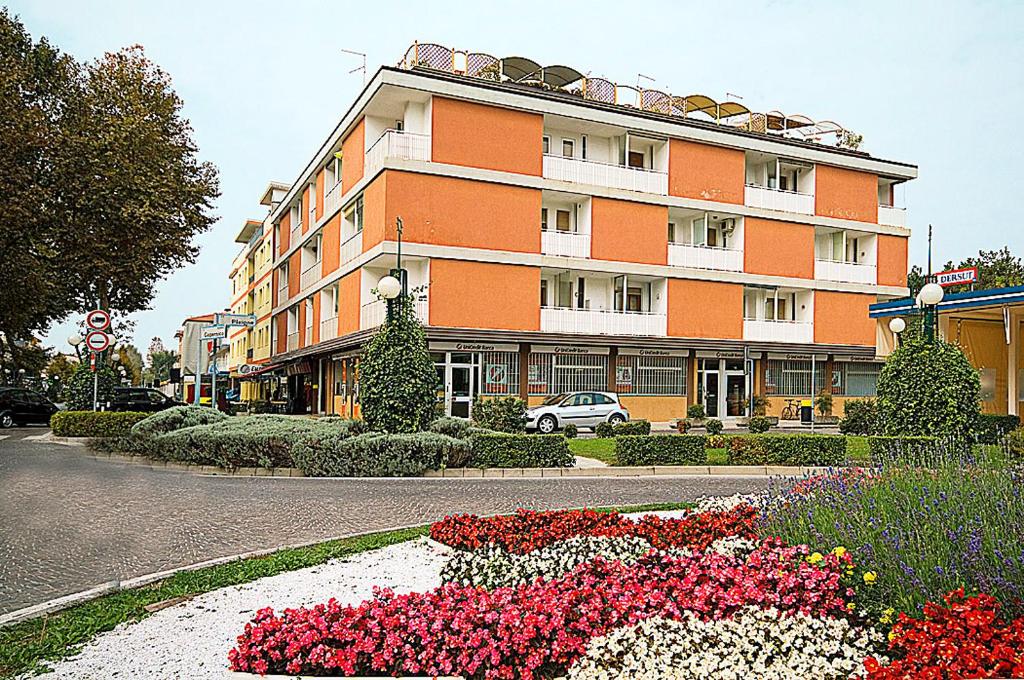 a large building with flowers in front of it at Appartamenti Foyer in Bibione