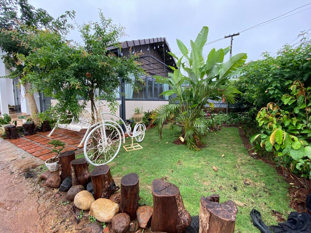 un jardin avec un vélo blanc assis dans la cour dans l'établissement Misuti Home, à Buôn Dhă Prŏng