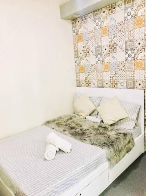 a white bed with pillows on it in a room at Close by landmarks and airport in Manila