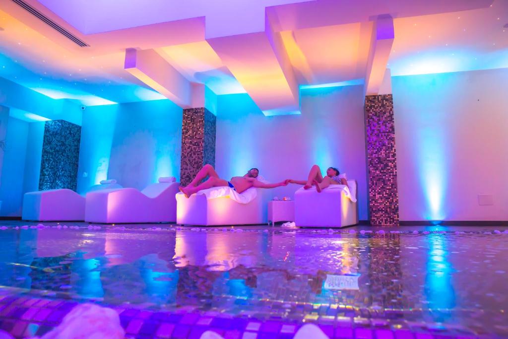 een groep mensen die op bedden in een kamer met verlichting liggen bij Hotel Degli Ulivi in Ferrandina