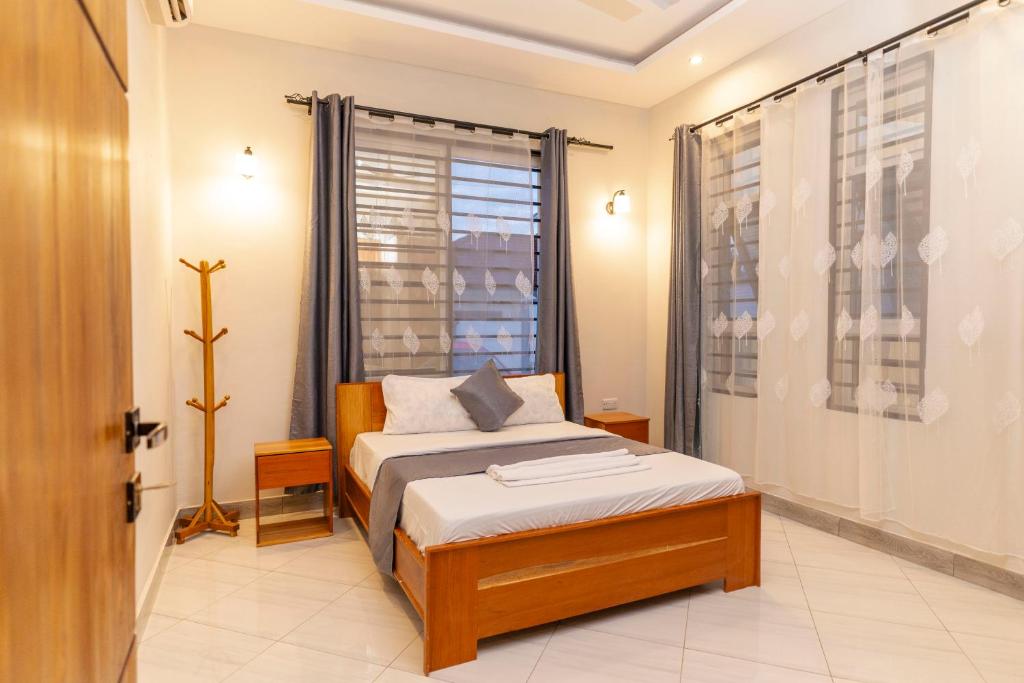 een kleine slaapkamer met een bed en een raam bij Tanga Home Rentals in Tanga