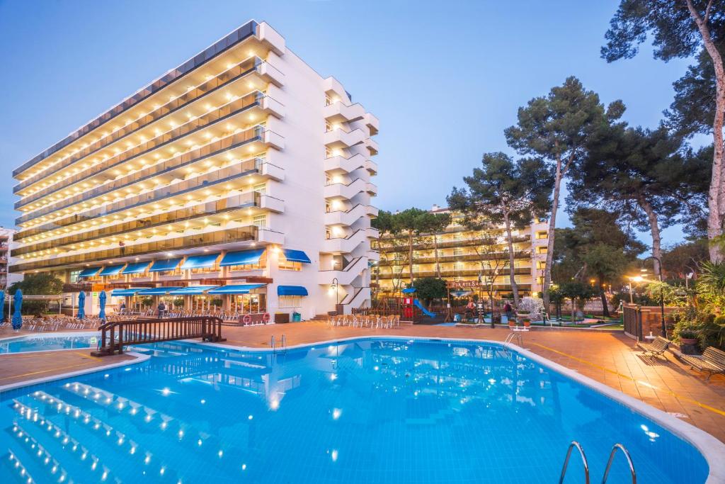 un hotel con piscina frente a un edificio en Hotel Marinada en Salou