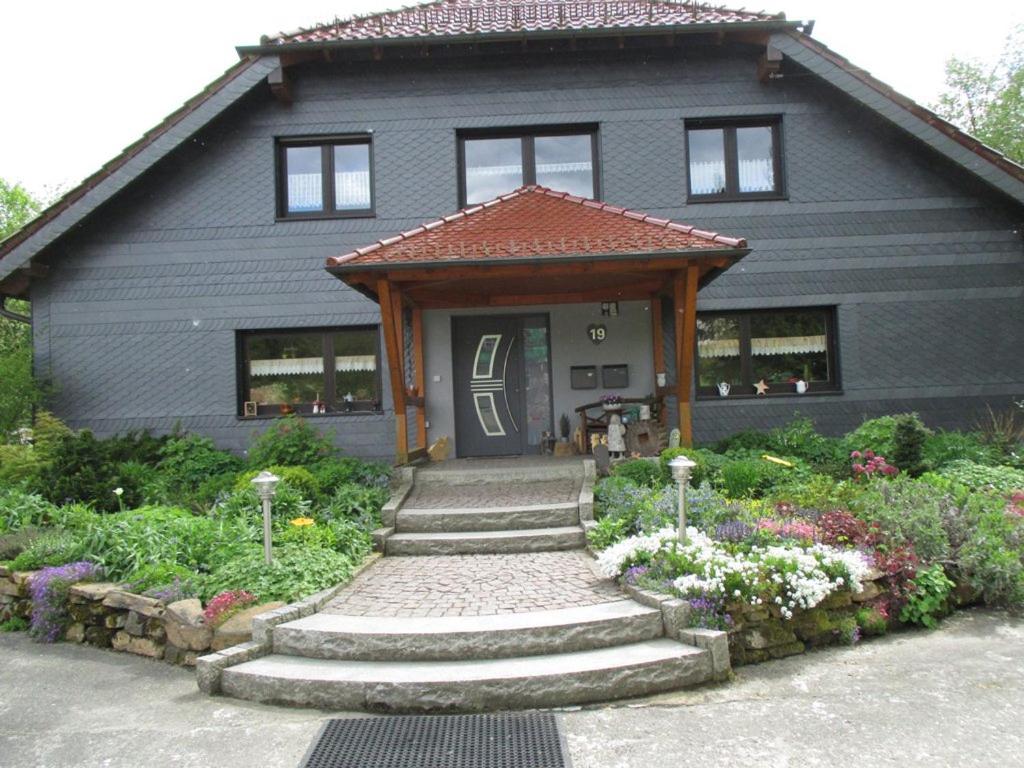 a gray house with a pathway leading to the front door at Ferienwohnung an der Lay in Bach