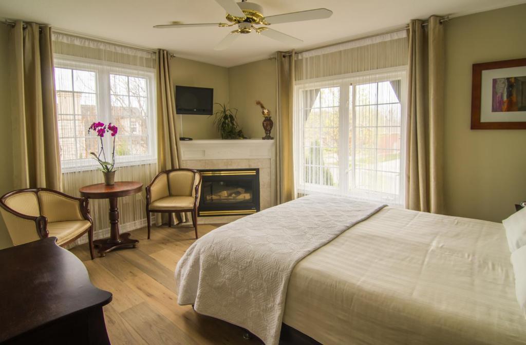 um quarto com uma cama, uma mesa e uma lareira em In Elegance em Niagara-on-the-Lake