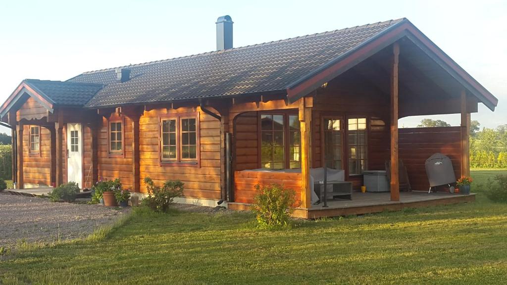 a large wooden cabin with a large window at Good Morning Bed and Breakfast in Härslöv
