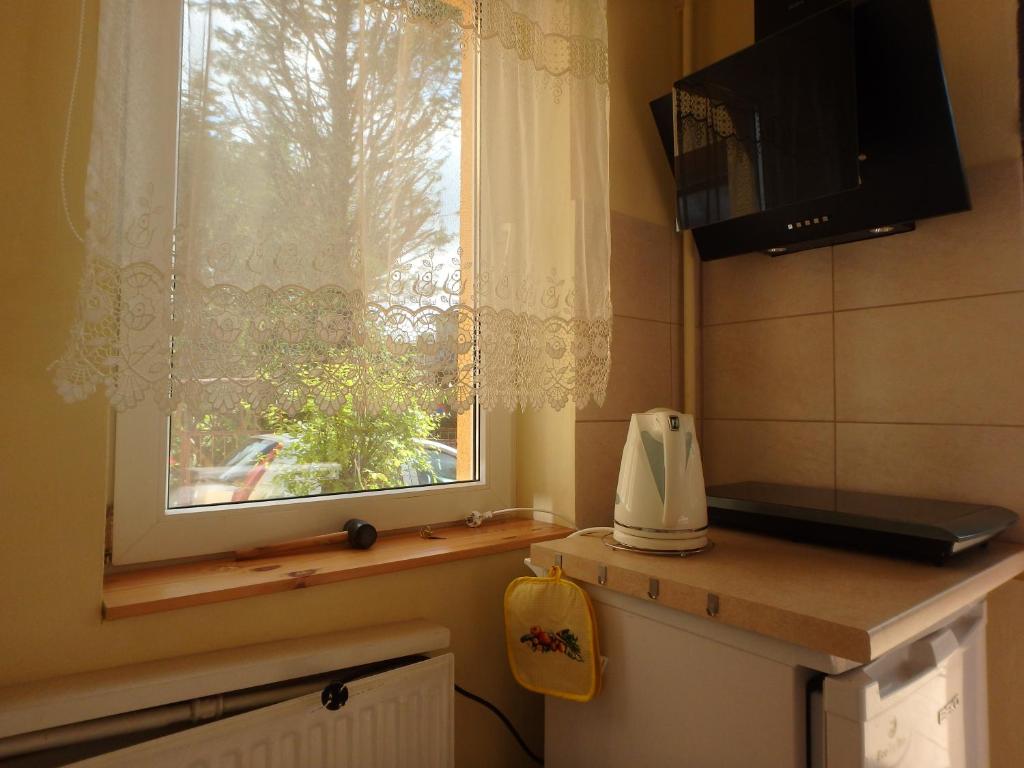 a small kitchen with a window and a microwave at Apartament CURIE - studio in Międzyzdroje