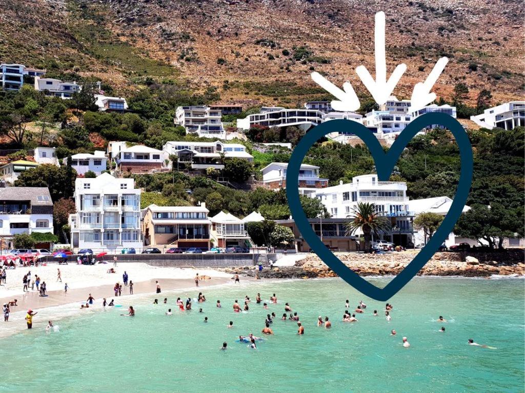 a group of people on a beach with a heart in the water at 'The View' on Bikini Beach, Seafront, 2 bedroom, Sleeps 4 in Gordonʼs Bay