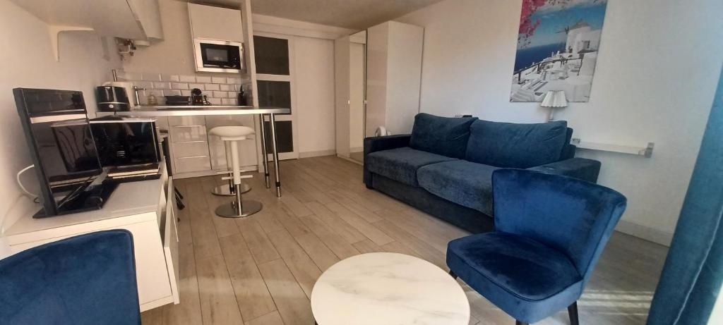 a living room with a blue couch and a table at Appartement bord de mer le Capitaine in Valras-Plage