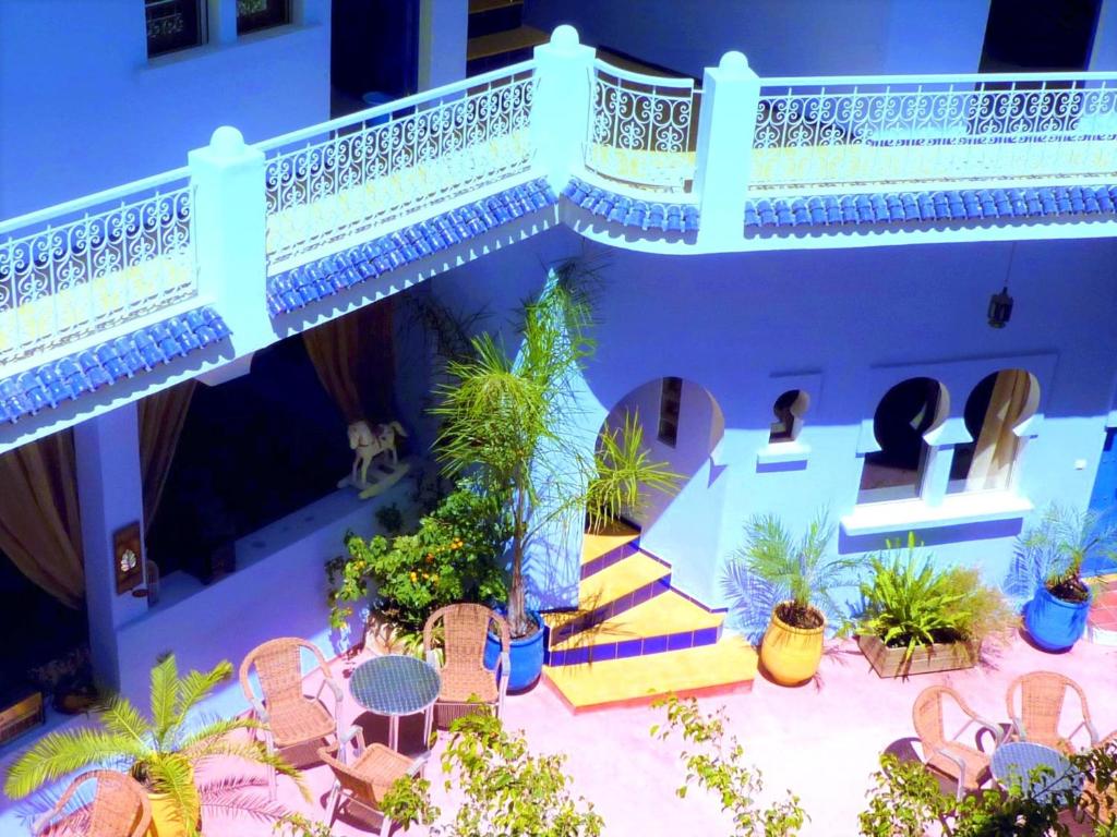 an outdoor patio with chairs and tables and a balcony at Dar Omar Khayam in Tangier
