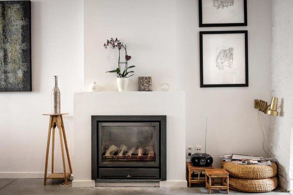 a living room with a fireplace and framed pictures at Csar Private Guesthouse in Bruges