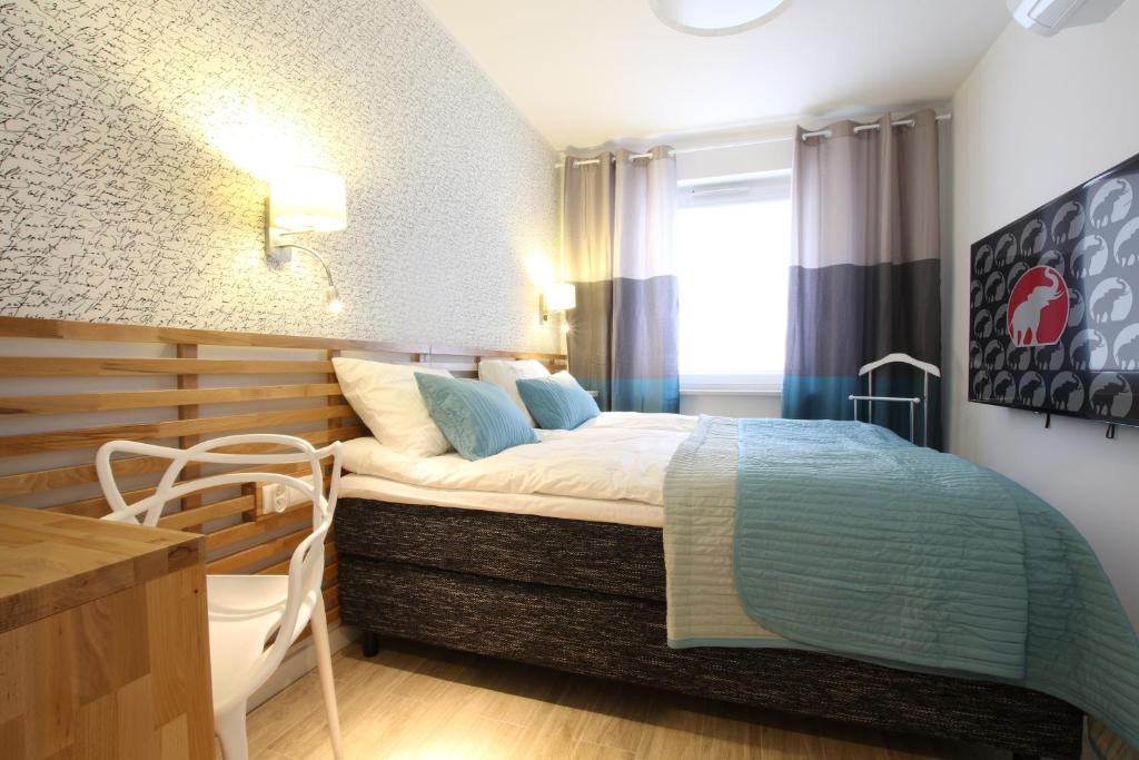 ブィドゴシュチュにあるApartamenty Bohaterów Kragujewca 6のベッドとデスクが備わるホテルルームです。