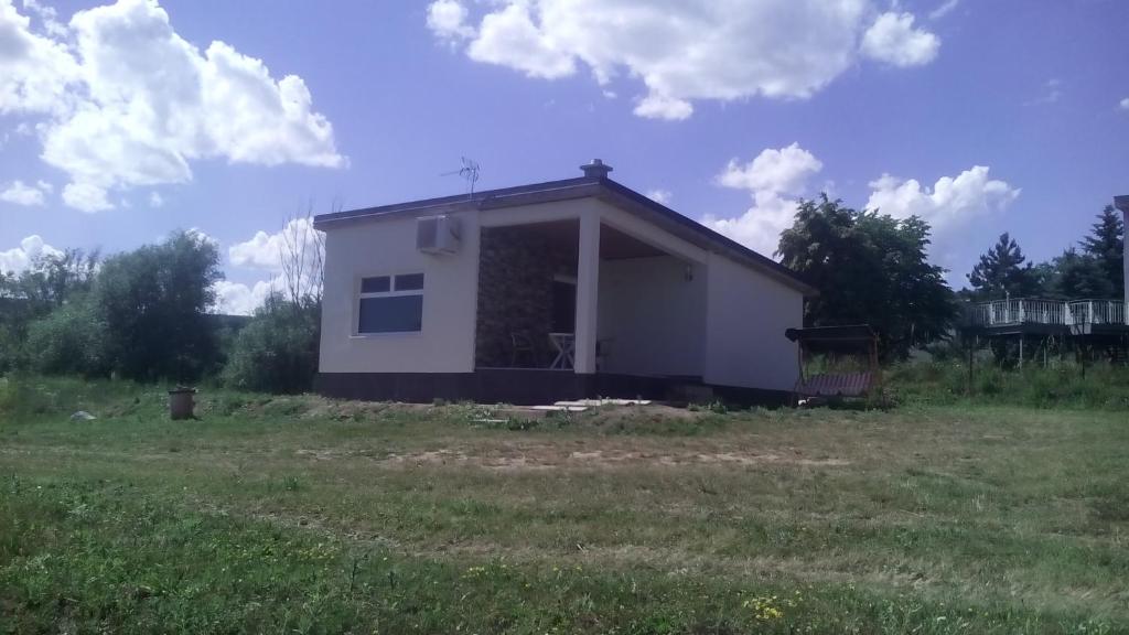 a small white house in the middle of a field at Apartmány Vihorlat I in Kaluža