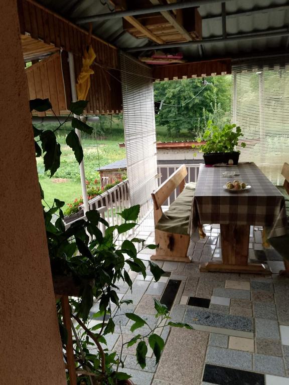eine Terrasse mit Tisch und Stühlen auf einer Veranda in der Unterkunft Secret garden in Visoko