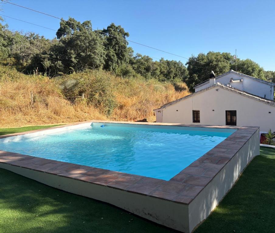 a swimming pool in the yard of a house at Cortijo Rural El Contador, con Piscina in Constantina