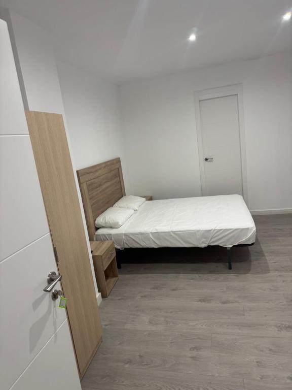 a small bedroom with a bed and a door at Nbm in Puerto de Gandía