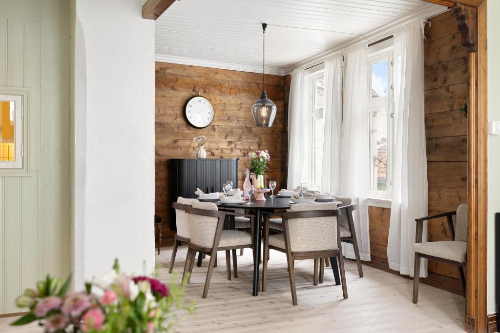 a dining room with a table and chairs and a clock at City Center Gem I Traditional Bergen Style in Bergen