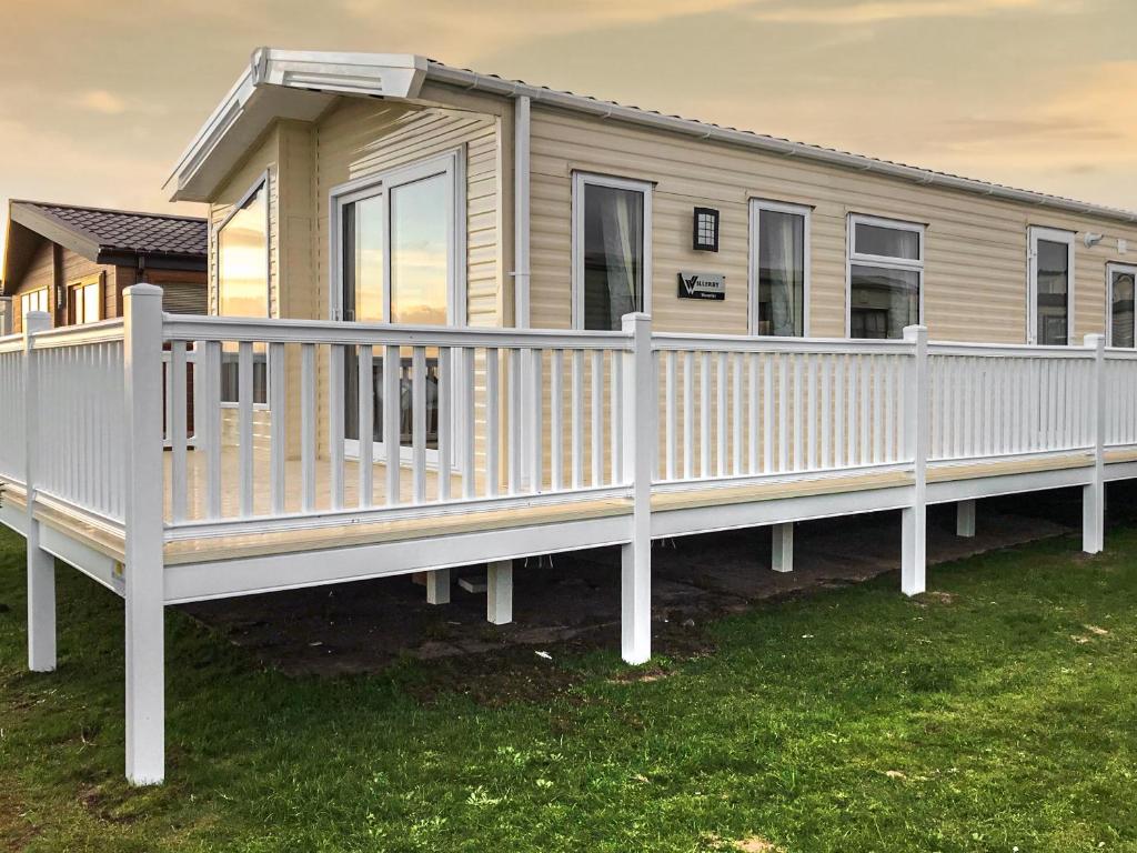 a mobile home with a white railing on a deck at Beeches Bay - Uk43975 in Mainsriddle