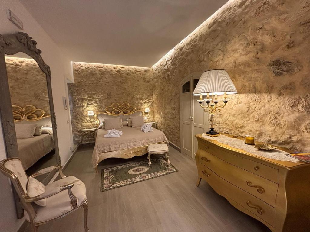 ein Schlafzimmer mit einem Bett, einer Kommode und einem Spiegel in der Unterkunft Angelica's House in Noto