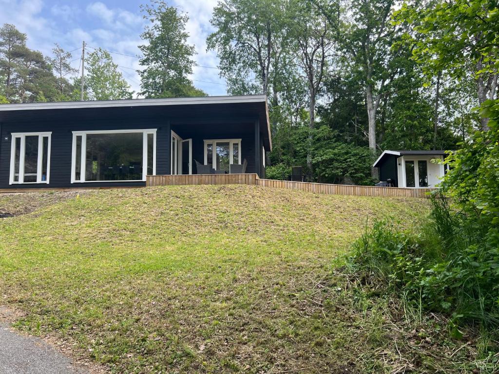 a small black house with a large yard at 3 bedroom Cabin, 5 min walk to the ocean, 1 hours drive from Oslo in Fredrikstad
