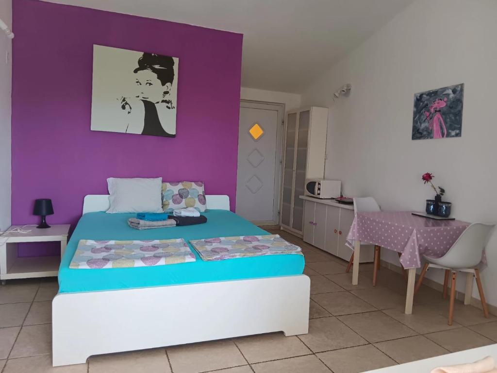 a bedroom with a bed and a purple wall at Art room JASMINA with sea view - Bikers and pets are welcome in Starigrad-Paklenica