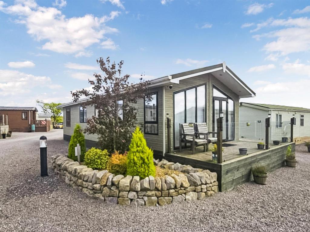 a small green modular home with a patio at Zion's Retreat in Plumbland