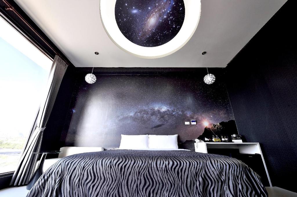 ein Schlafzimmer mit einem Bett und einem Fenster mit dem Universum in der Unterkunft CoCo Motel Boutique in Puli