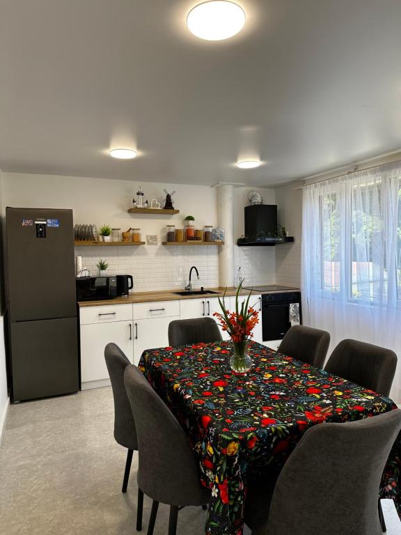 a kitchen with a dining room table with flowers on it at Green Azure - მწვანე ლაჟვარდი in Kvariat'i