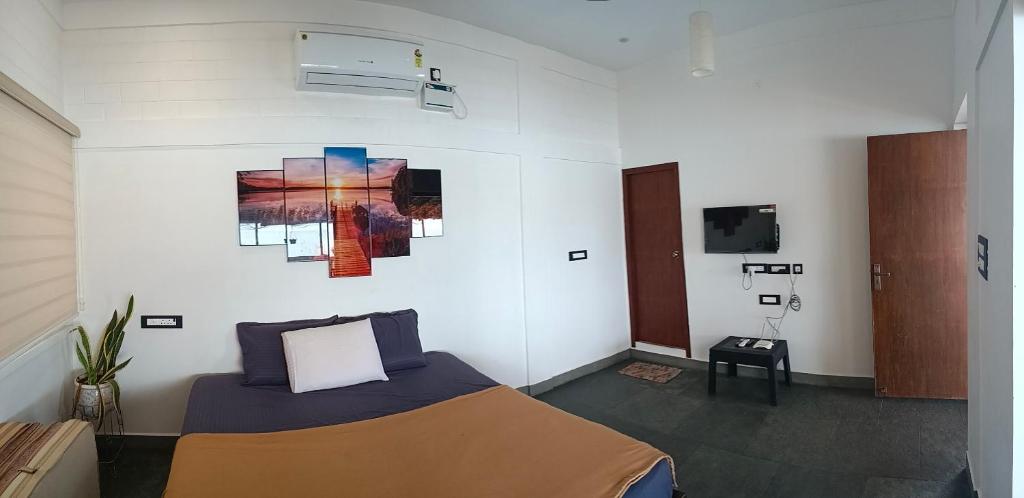 a bedroom with a bed and a painting on the wall at Villa Ande - Beach Homestay Pondicherry in Kālapettai