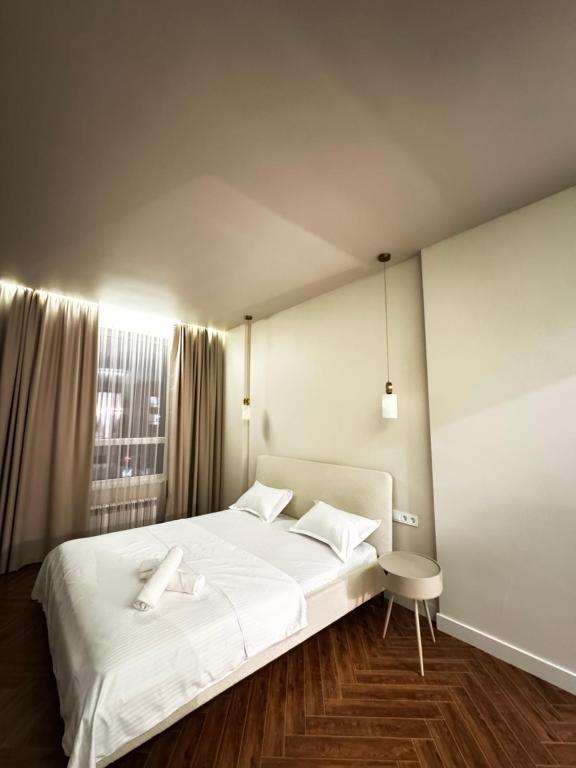 a bedroom with a white bed and a window at 4х комнатная Премиум класс возле Хан шатыра in Astana