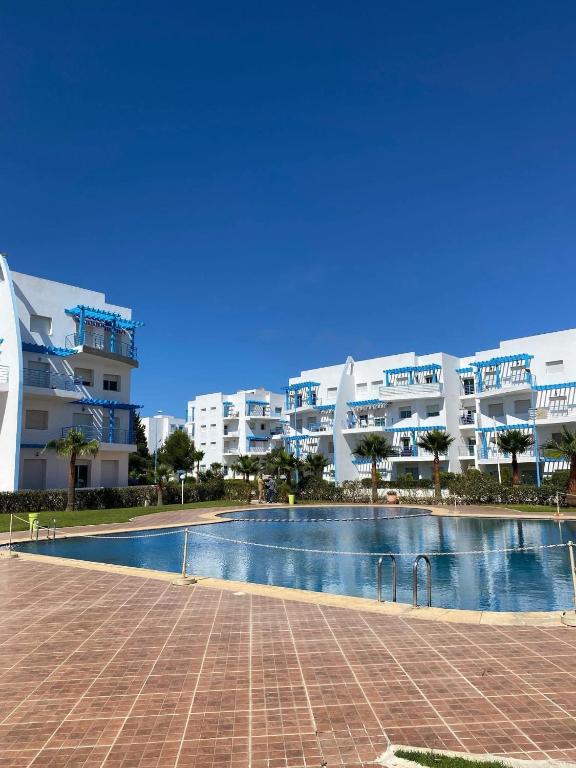 a swimming pool in front of a large building at Riviera Beach in Cabo Negro
